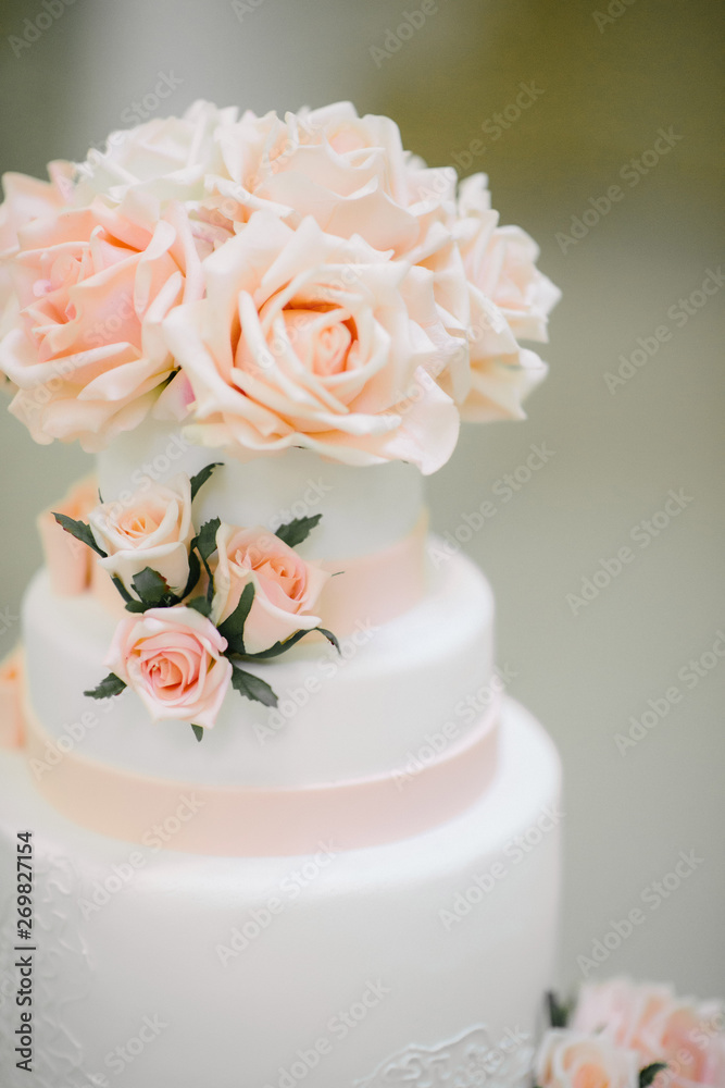 Big white wedding cake with fruit is on the table