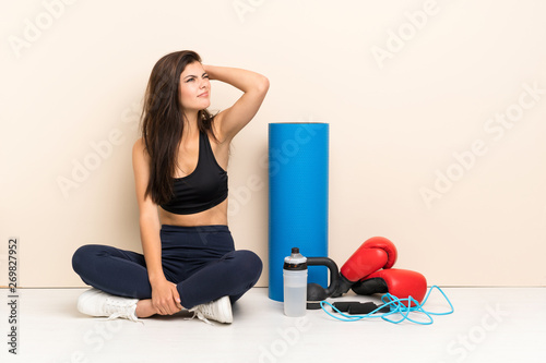 Teenager sport girl sitting on the floor having doubts