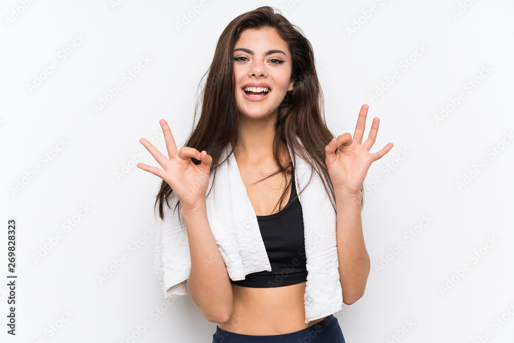 Teenager sport girl over isolated white background showing an ok sign with fingers Teenager sport girl over isolated white background showing an ok sign with fingers
