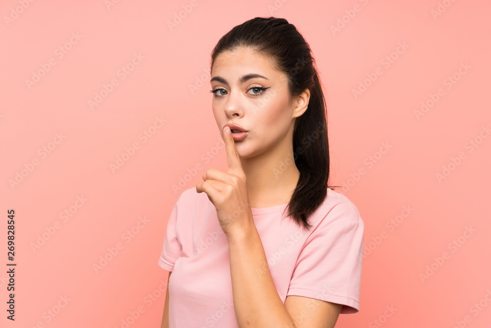 Teenager girl over isolated pink background doing silence gesture Teenager girl over isolated pink background doing silence gesture