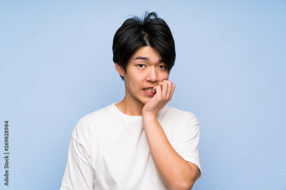Asian man on isolated blue background nervous and scared Asian man on isolated blue background nervous and scared