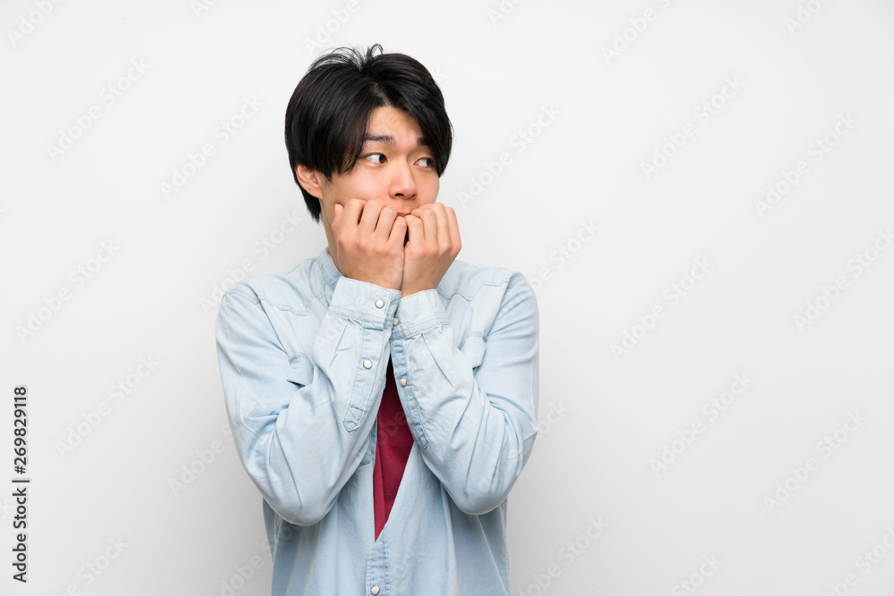Asian man on isolated white background nervous and scared putting hands to mouth Asian man on isolated white background nervous and scared putting hands to mouth