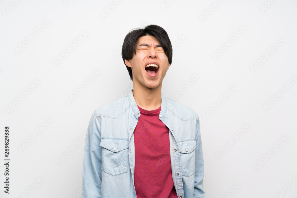 Asian man on isolated white background shouting to the front with mouth wide open Asian man on isolated white background shouting to the front with mouth wide open
