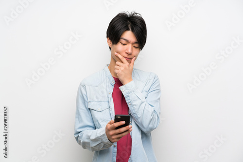 Asian man on isolated white background thinking and sending a message