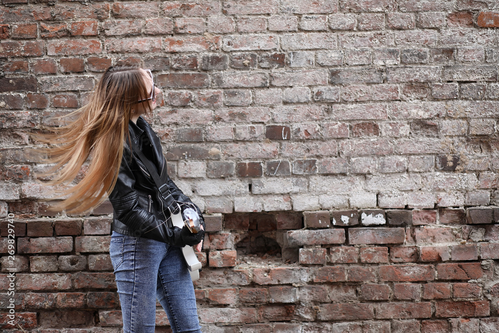 A rock musician girl in a leather jacket with a guitar A rock musician girl in a leather jacket with a guitar
