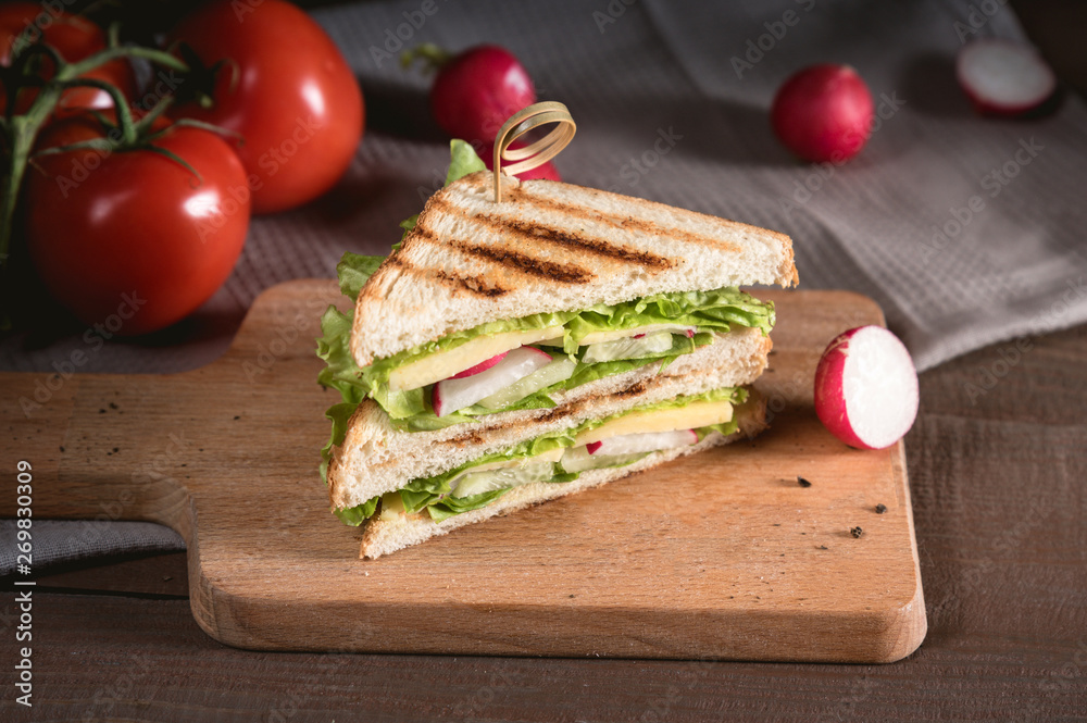 Club sandwich with vegetables on rustic background Club sandwich with vegetables on rustic background