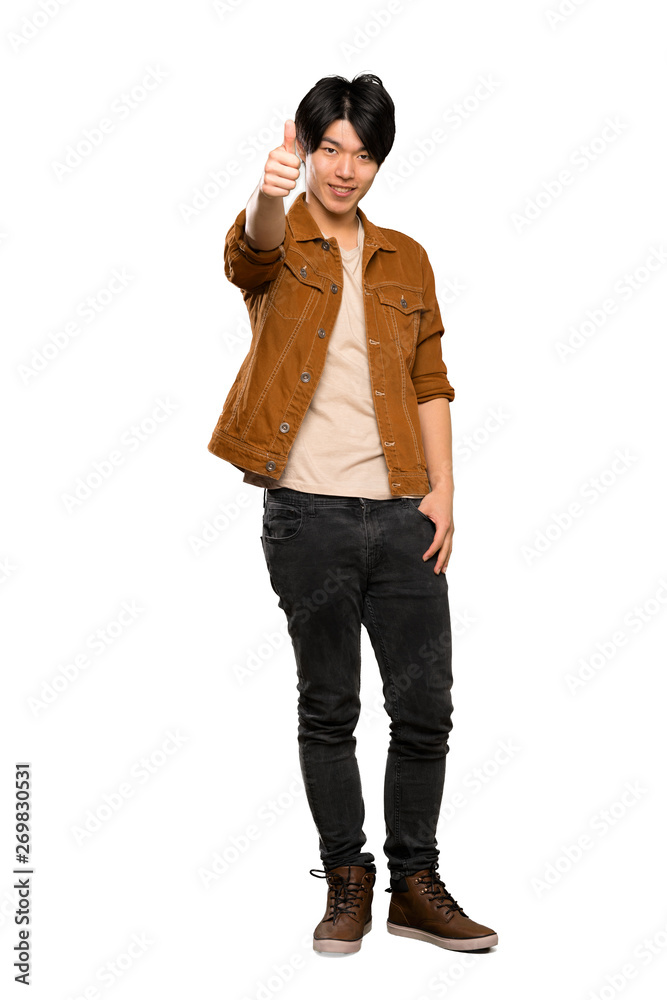 A full-length shot of a Asian man with brown jacket with thumbs up because something good has happened over isolated white background A full-length shot of a Asian man with brown jacket with thumbs up because something good has happened over isolated white background