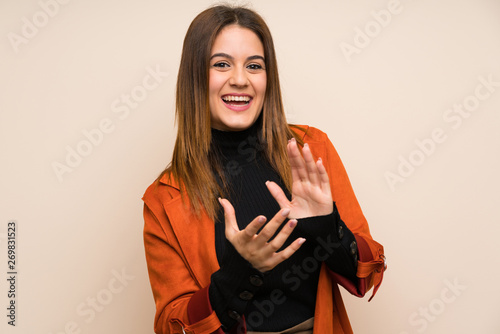 Young woman with coat applauding