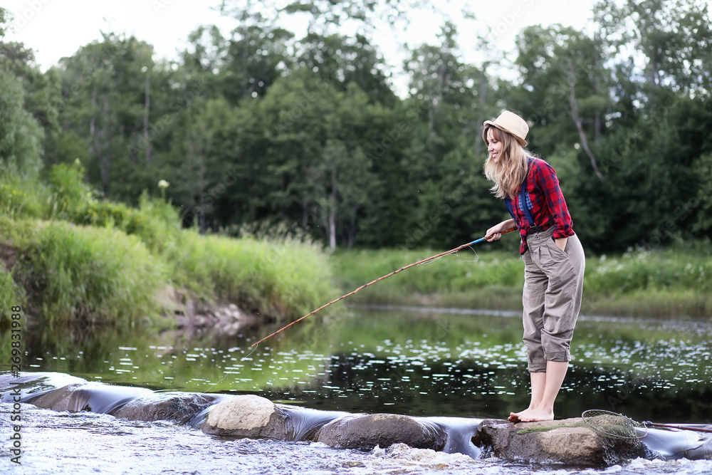 Girl by the river with a fishing rod