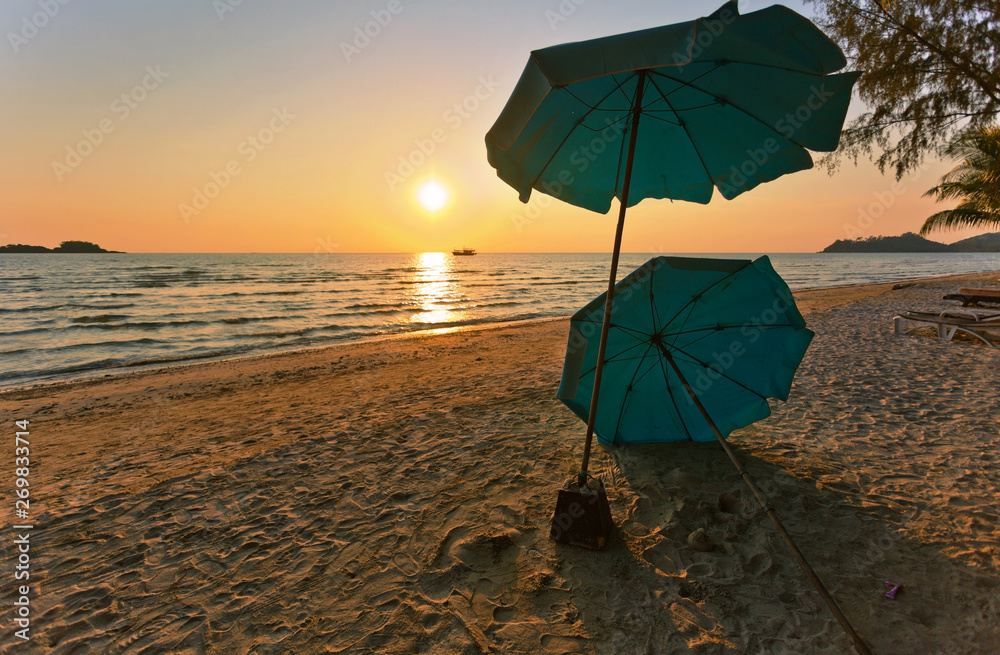 Wooden chairs and umbrellas on sand beach