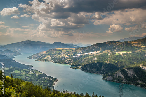 Lac de Serre-Poncon in the Alps is one of the largest artificial lakes in Europe and is surrounded by hills and mountains with stunning views of the lake, Hautes Alpes, French Alps.