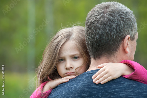Portrait of one sad daughter hugging her father
