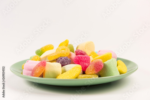 Plate with sweets isolated on white background. Gummy candies and marshmallow.