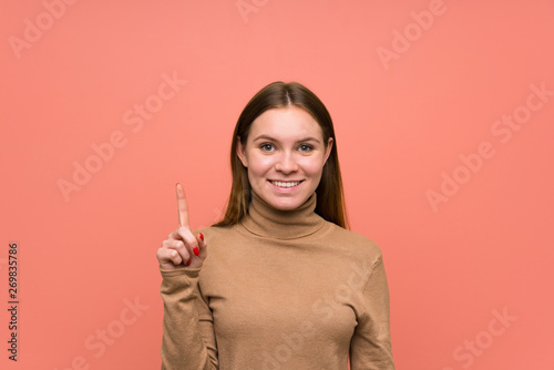 Young woman over colorful background pointing with the index finger a great idea