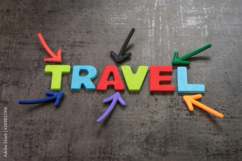Travel, tourism concept, colorful arrows pointing to the word Travel at the center of black chalkboard wall, new trend for people to travel the world to gain happiness