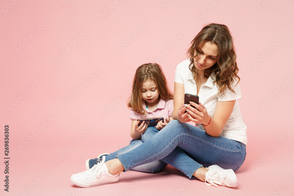 Woman in light clothes have fun with cute child baby girl. Mother, little kid daughter isolated on pastel pink wall background, studio portrait. Mother's Day, love family, parenthood childhood concept Woman in light clothes have fun with cute child baby girl. Mother, little kid daughter isolated on pastel pink wall background, studio portrait. Mother's Day, love family, parenthood childhood concept
