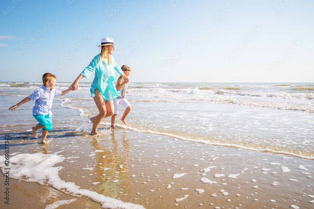 mother and her children playing on the beach