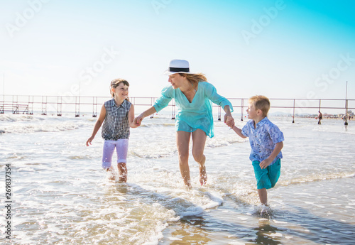 mother and her children playing on the beach