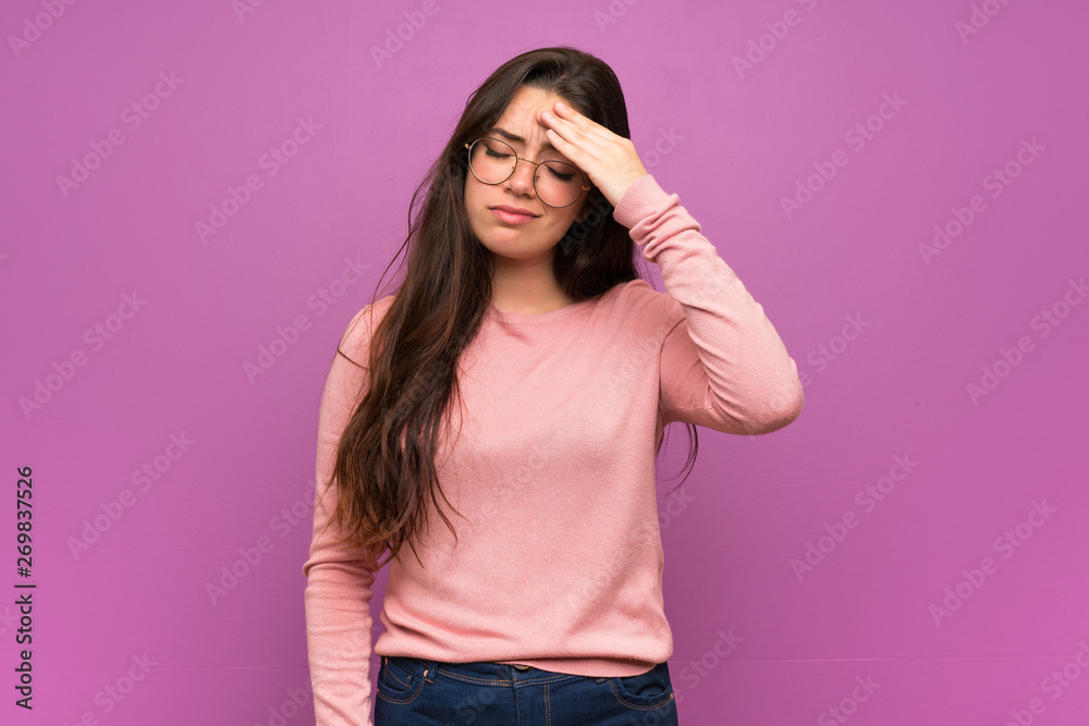 Teenager girl over purple wall with tired and sick expression