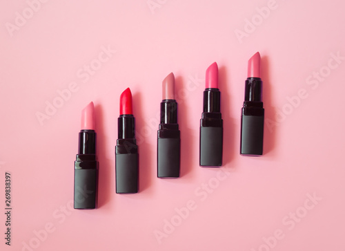 Set of beautiful lipsticks on pink background photo