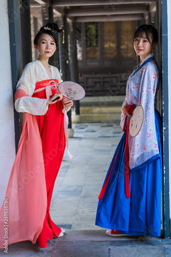 Two young women wearing in Chinese Han clothing in traditional Chinese buildings. photo