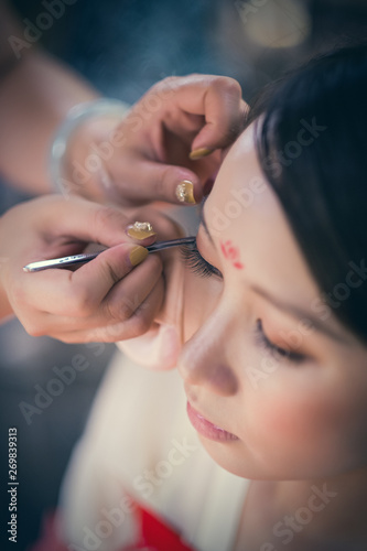 A Chinese woman is doing makeup before a traditional opera show.