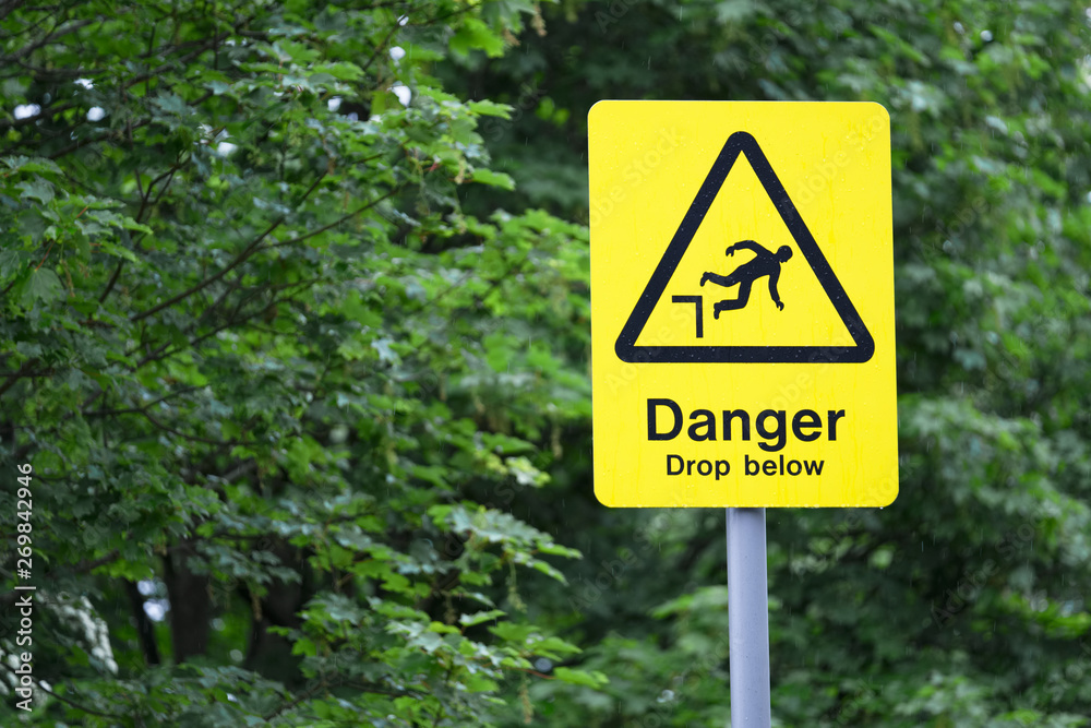 Danger drop below yellow triangle warning sign