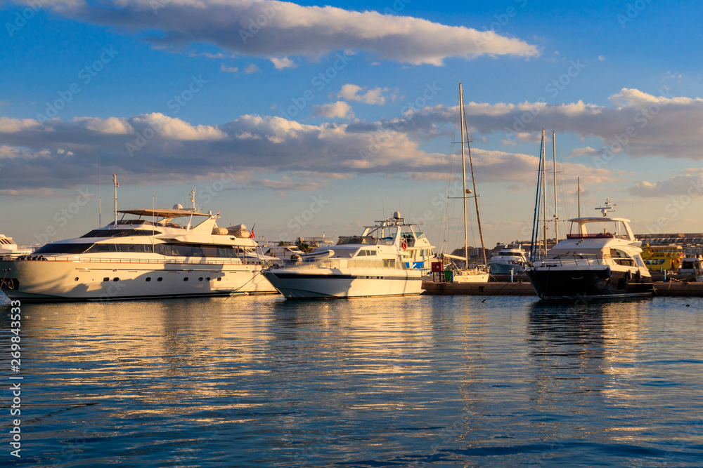 Fototapeta premium White yachts in the sea harbor of Hurghada, Egypt. Port with tourist boats on the Red Sea
