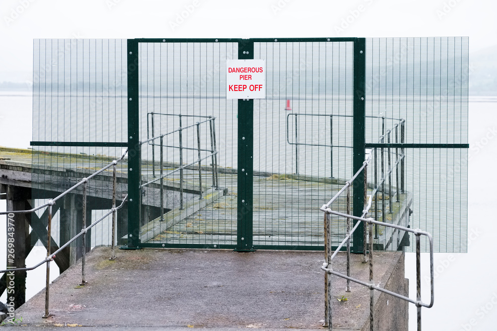 Dangerous pier keep off sign on abandoned sea jetty Dangerous pier keep off sign on abandoned sea jetty