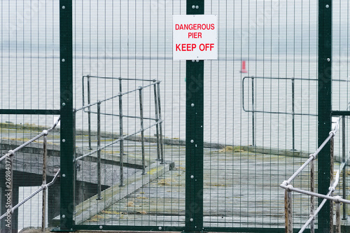 Dangerous pier keep off sign on abandoned sea jetty