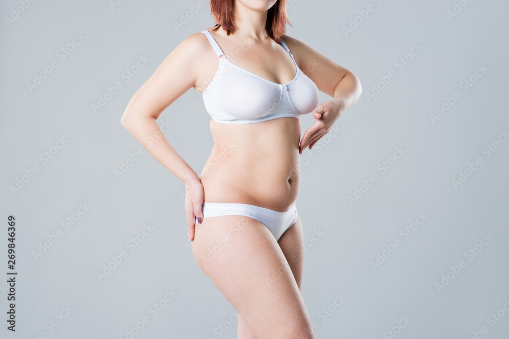 Woman with fat flabby belly, overweight female body on gray background - obrazy, fototapety, plakaty 