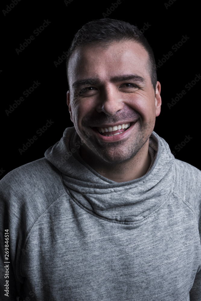 Studio portrait of a smiling man looking at the camera. Isolated on black background. Vertical. Studio portrait of a smiling man looking at the camera. Isolated on black background. Vertical.