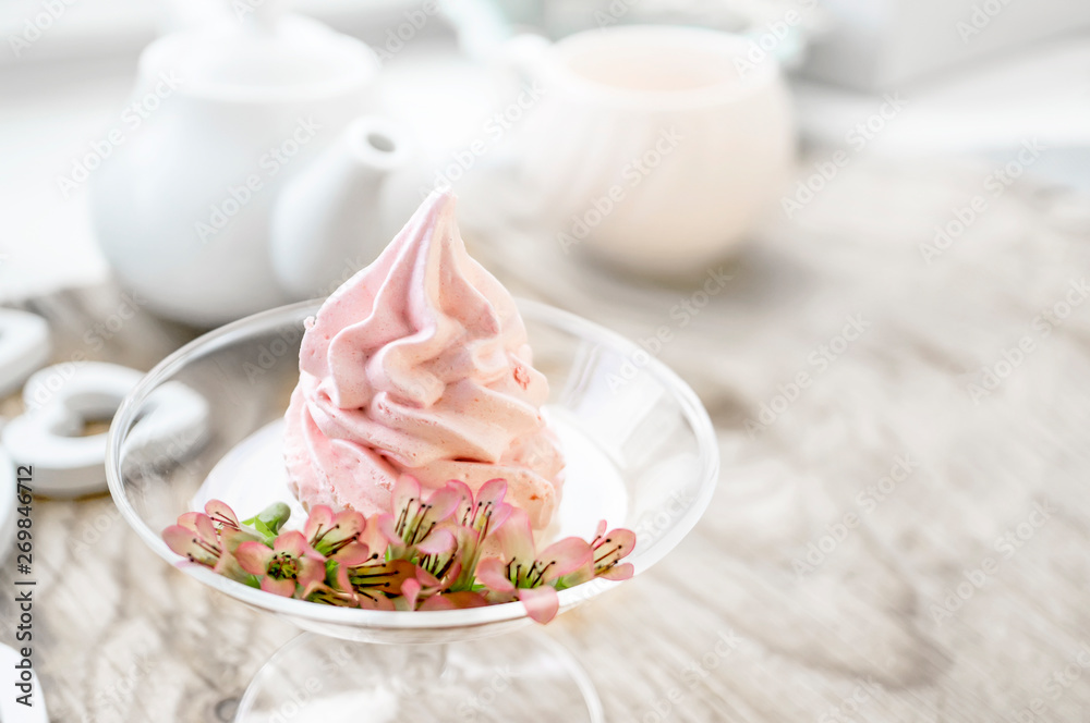 Delicate flowers Kalanchoe on the background Delicate pink apple marshmallow handmade in a glass transparent vase. Marshmallow, dessert. Copy space