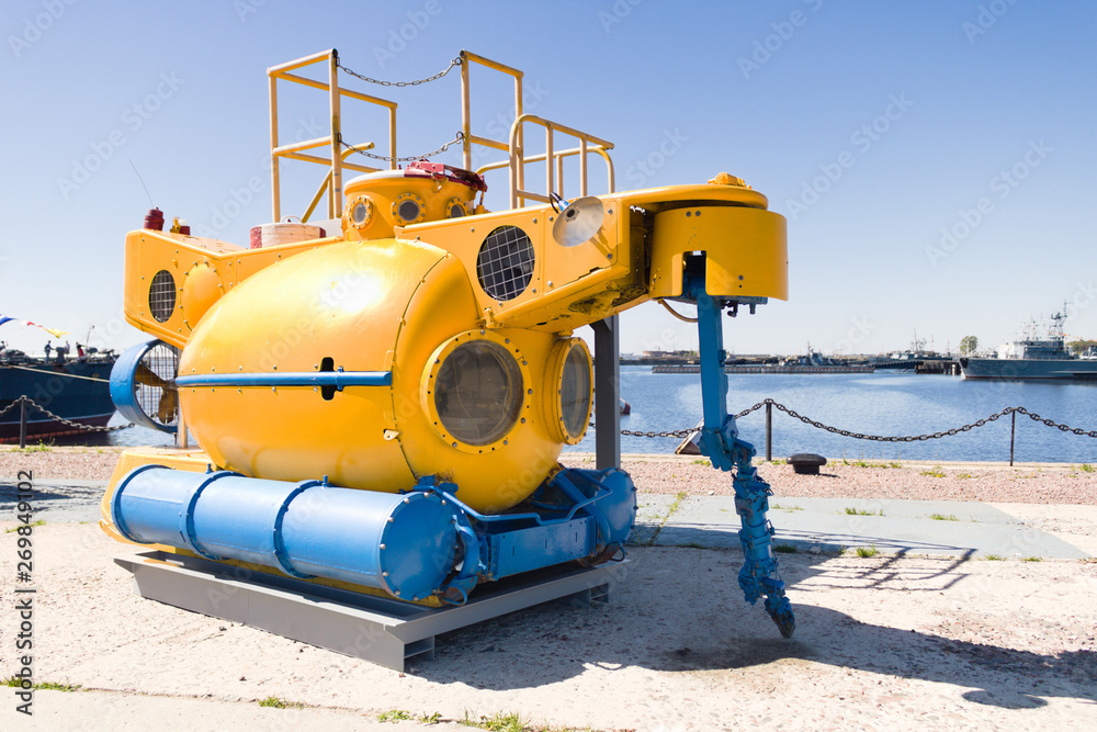 Small yellow rescue bathyscaphe with illuminators and mechanical manipulators