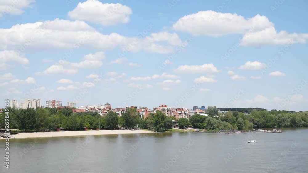 View of residential building and city beach Strand in Novi Sad, Serbia with Danube river blue sky with white clouds and sunshades parasols on the sand View of residential building and city beach Strand in Novi Sad, Serbia with Danube river blue sky with white clouds and sunshades parasols on the sand