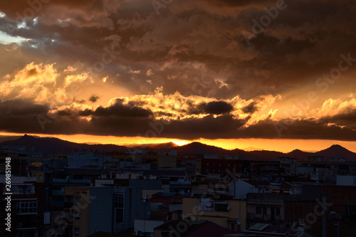 Sunset with orange sky and dark city © Javier