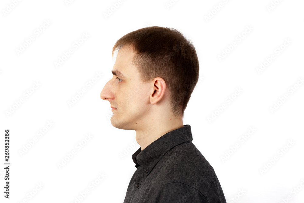 Tall thin young man stands on white background in profile Tall thin young man stands on white background in profile