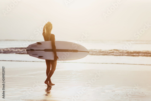 Sticker Surfer girl surfing looking at ocean beach sunset summer time