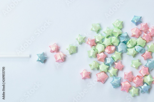 colorful star paper spreading from plastic straw on white background © pedphoto36pm