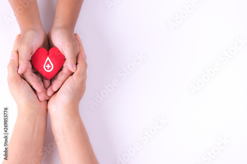 Fototapet Woman and child hands holding red heart  for blood donation concept,World blood donor day, health care love, hope and family concept, world heart day,world health day