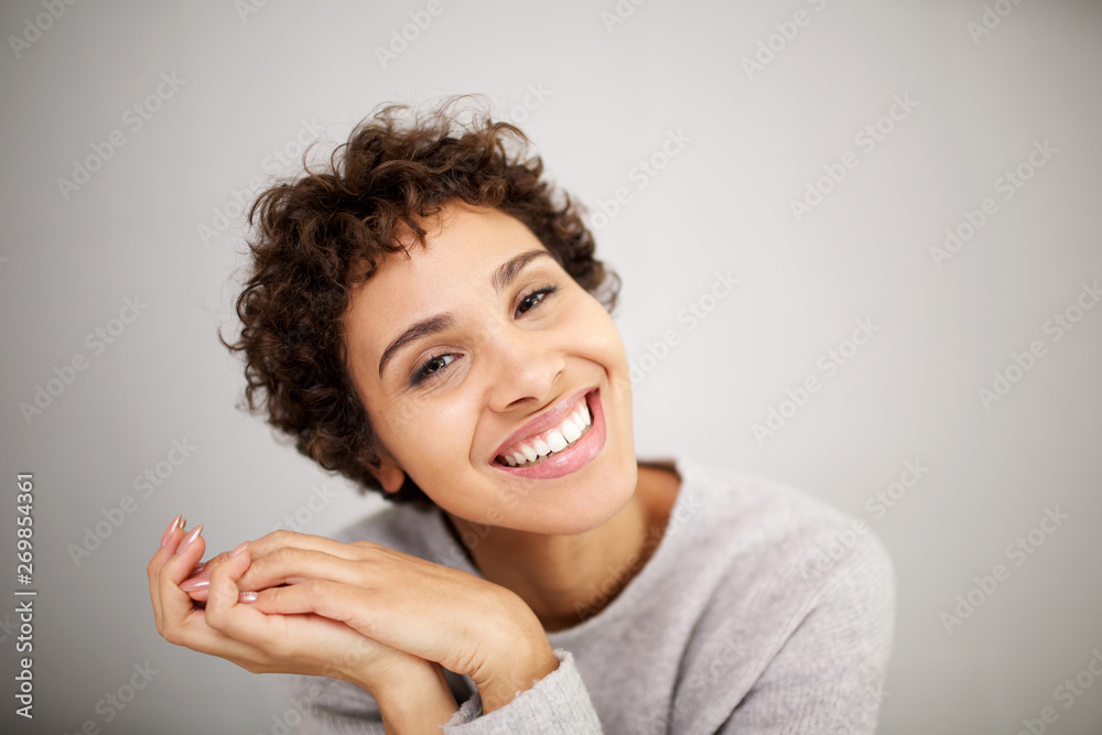 Close up portrait happy young african american woman smiling against against white wall