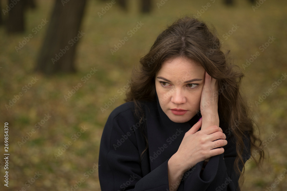 portrait of serious young woman in autumn park