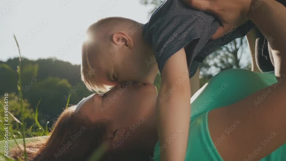 Mother and son having fun on the grass in a park