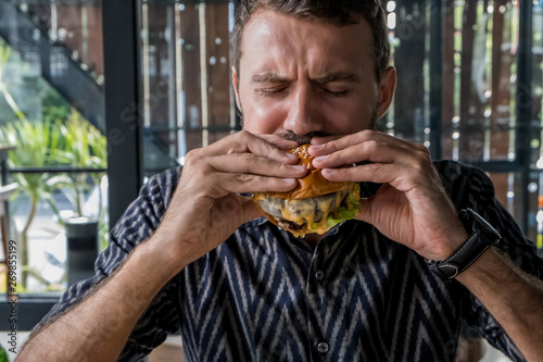 Man eating delicious burger and french fries