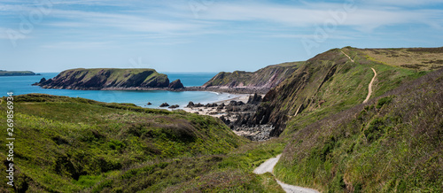 Wild rugged beach on a sunny day at low tide. With cliffs behind. Marloes Sands, Pembrokeshire. UK