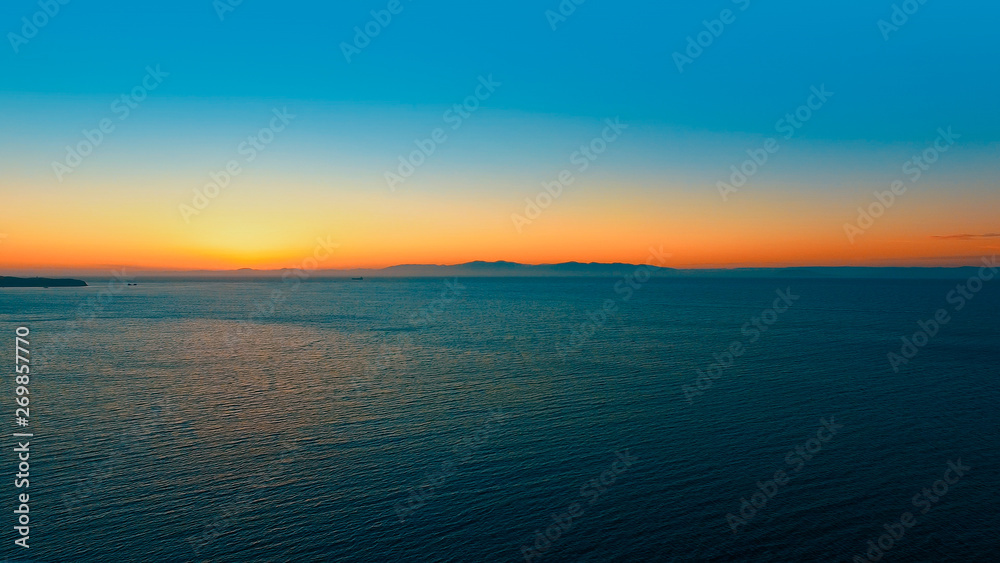 Seascape with orange sunset over the horizon.