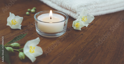 Spa und Wellness Kerze, Jasmin Blüten, Handtücher auf Holz