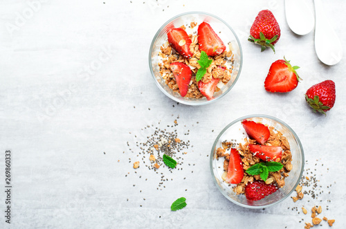 Tasty Strawberry Dessert, Homemade Yogurt with Strawberries, Granola and Chia Seeds over Bright Background