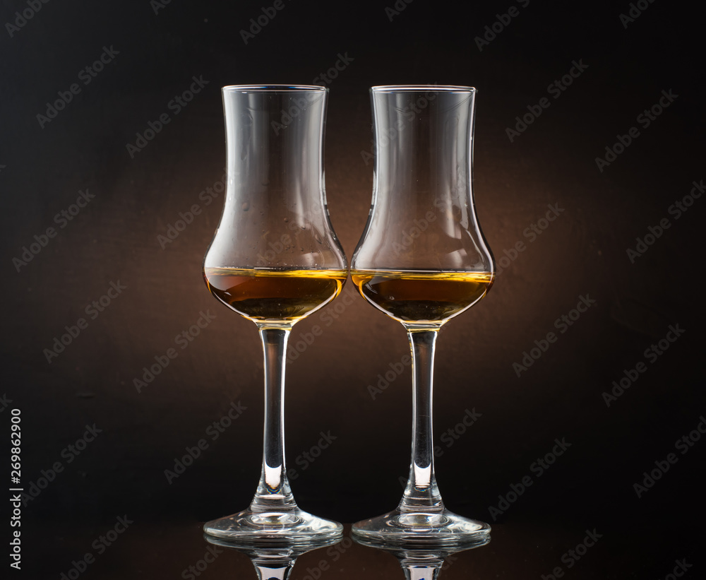 Two glasses of cognac sniffer on a colored dark background Two glasses of cognac sniffer on a colored dark background