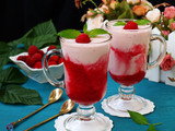 Milk cocktail with raspberries in glasses on a blue background, the photo there is fresh raspberries in a bowl and dessert spoons